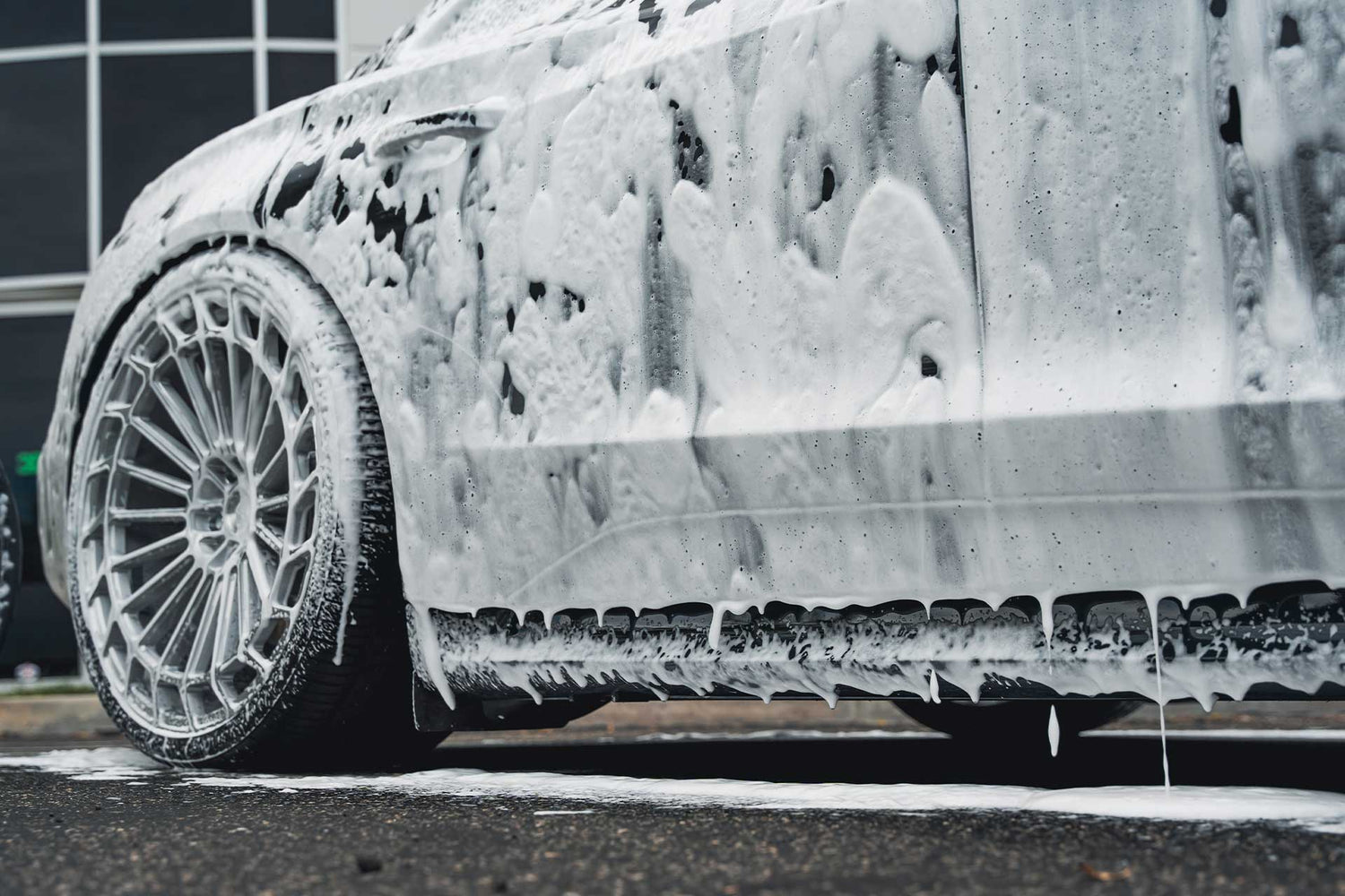 side of car dripping with foamy car soap